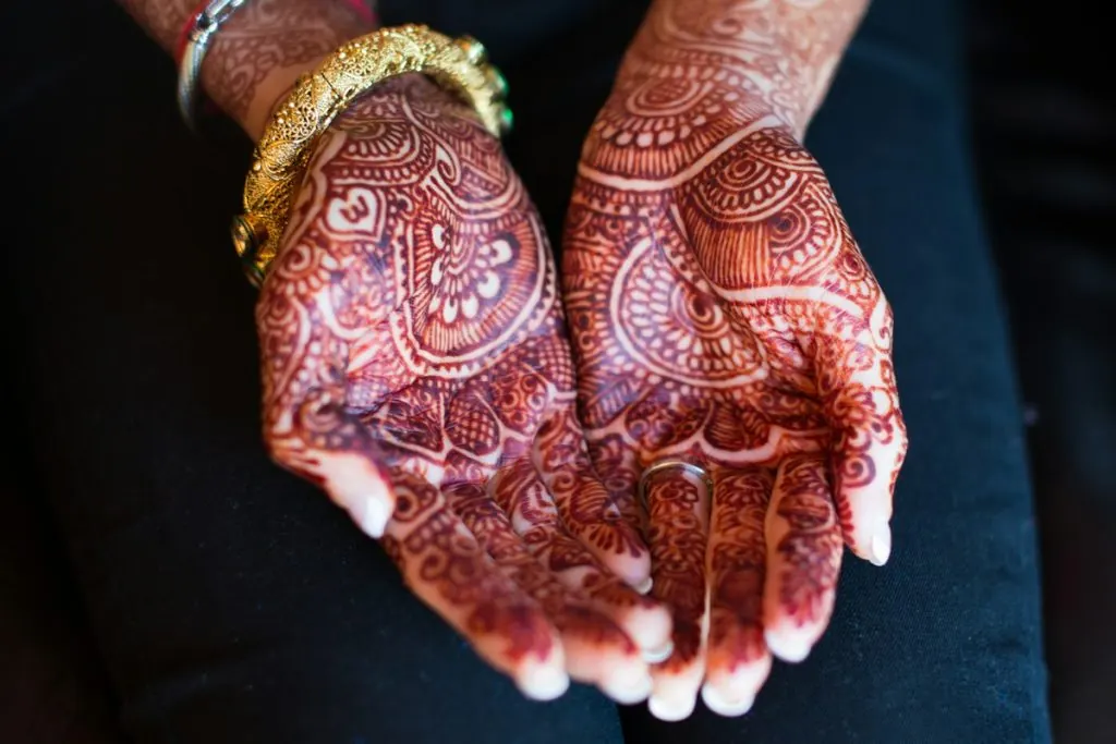 Close detail of mehendi applied to a bride's hands ahead of her celebration